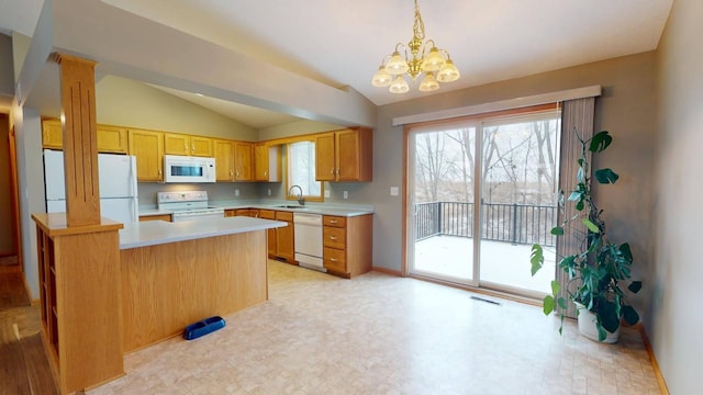 kitchen with pendant lighting, sink, white appliances, lofted ceiling, and kitchen peninsula