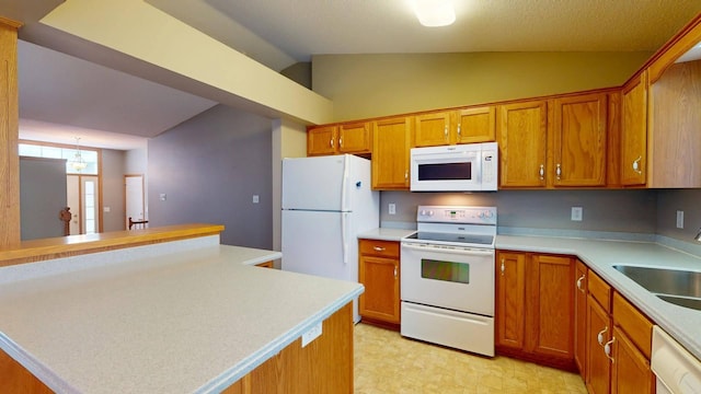 kitchen featuring white appliances, lofted ceiling, sink, and a kitchen island