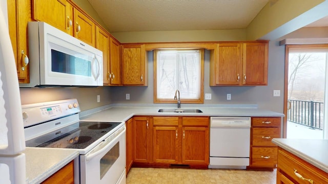 kitchen featuring vaulted ceiling, sink, a textured ceiling, and white appliances