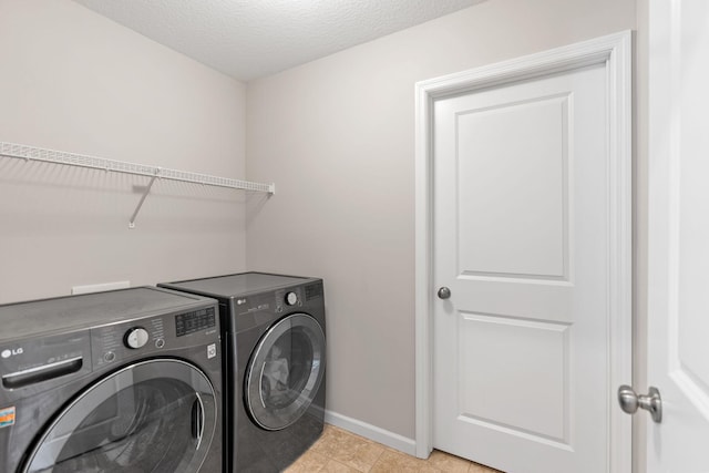 clothes washing area featuring light tile patterned floors, independent washer and dryer, and a textured ceiling