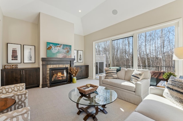 living room with a high ceiling, carpet, a tile fireplace, and recessed lighting