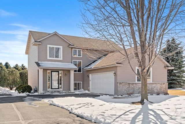 view of front of home featuring brick siding, a garage, and a shingled roof