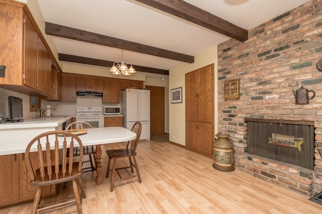 kitchen with white appliances, light hardwood / wood-style flooring, extractor fan, a brick fireplace, and a chandelier