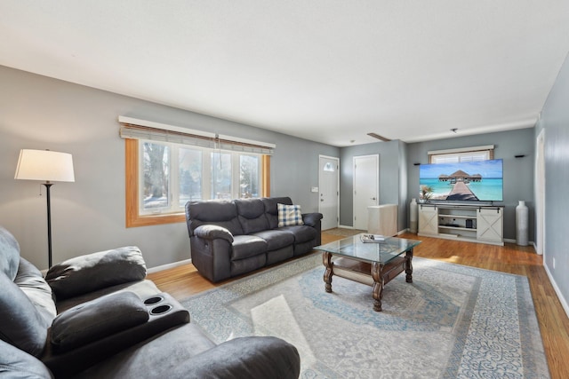 living area featuring baseboards and wood finished floors