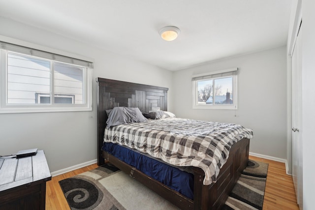 bedroom with light wood-type flooring and baseboards