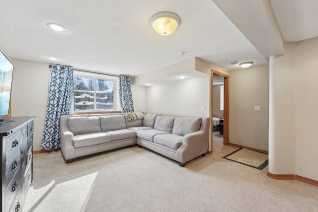 living area featuring light carpet, baseboards, and a textured ceiling