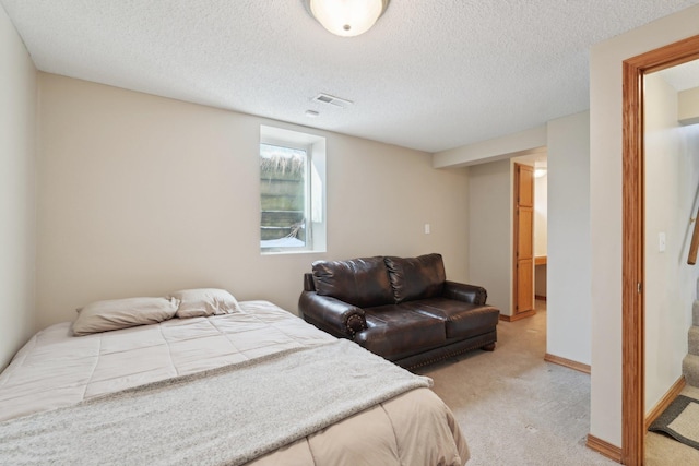 carpeted bedroom featuring baseboards, visible vents, and a textured ceiling