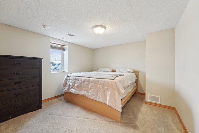 bedroom with light colored carpet, visible vents, a textured ceiling, and baseboards