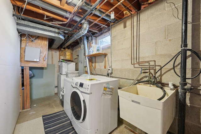 washroom with laundry area, a sink, and washing machine and clothes dryer