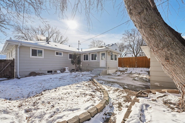 snow covered property featuring fence