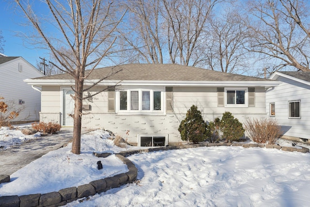 view of front of house with a shingled roof and brick siding