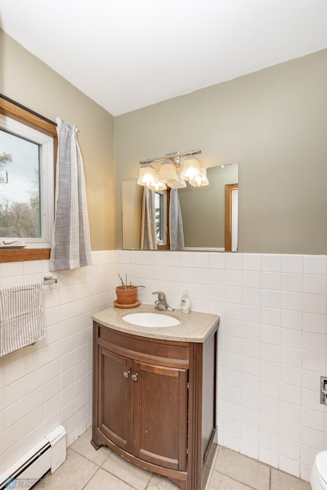 bathroom featuring a baseboard heating unit, tile patterned floors, vanity, and tile walls