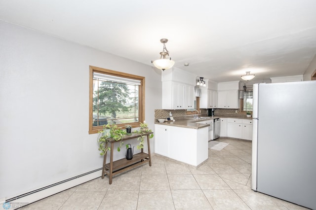 kitchen with freestanding refrigerator, tasteful backsplash, pendant lighting, a baseboard heating unit, and white cabinets