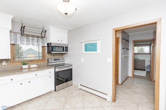 kitchen with tasteful backsplash, baseboard heating, light countertops, stainless steel appliances, and white cabinets