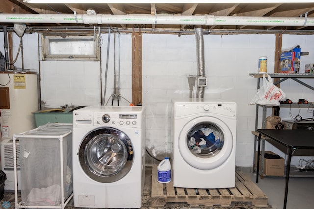 clothes washing area featuring washing machine and clothes dryer, laundry area, a sink, and water heater