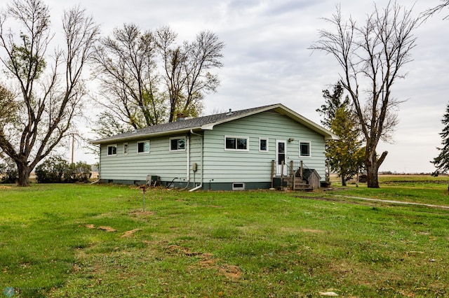 back of property with a chimney and a yard