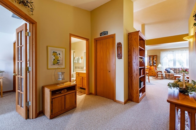 corridor with light carpet and a high ceiling