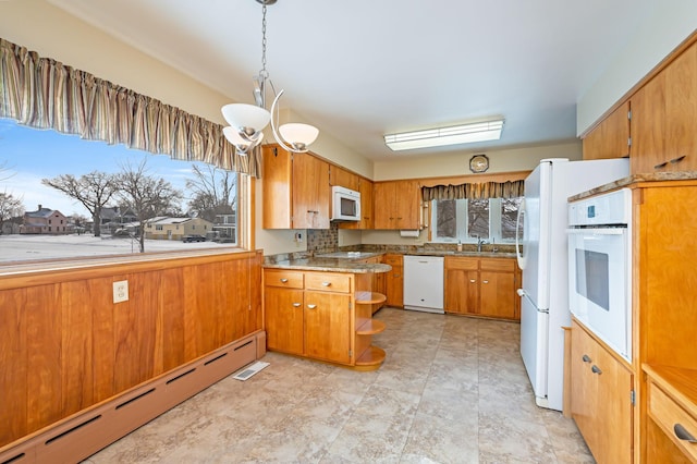 kitchen featuring an inviting chandelier, hanging light fixtures, white appliances, and a baseboard radiator