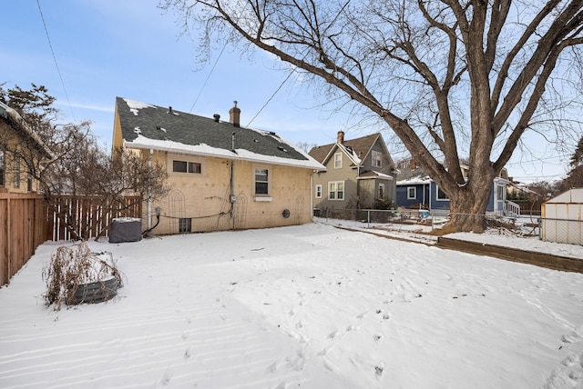 snow covered house with central AC unit