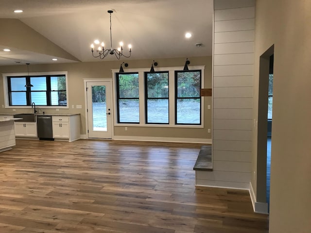 interior space featuring vaulted ceiling, dark hardwood / wood-style floors, sink, and an inviting chandelier