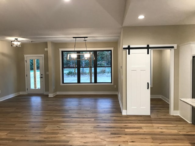 entrance foyer with a barn door, plenty of natural light, and hardwood / wood-style floors