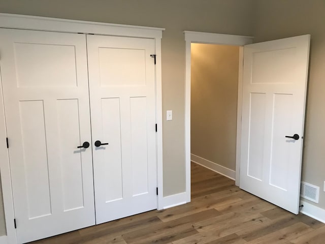 unfurnished bedroom with hardwood / wood-style floors and a closet