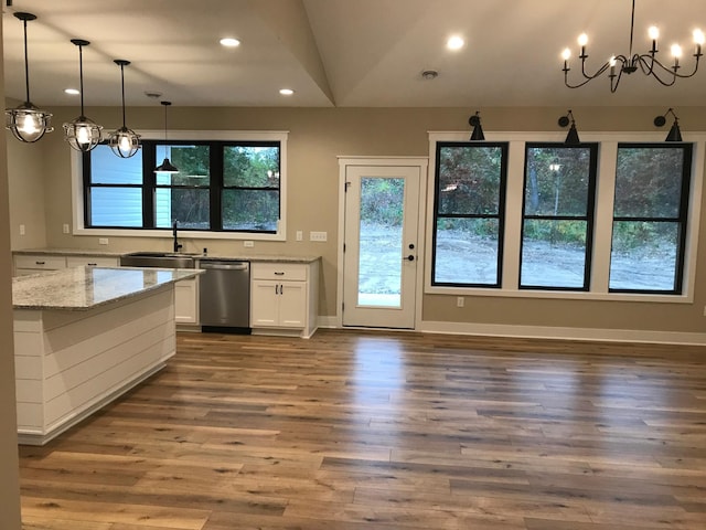 kitchen with pendant lighting, sink, light stone countertops, white cabinets, and stainless steel dishwasher