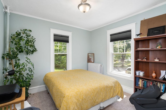 carpeted bedroom featuring radiator, multiple windows, and baseboards