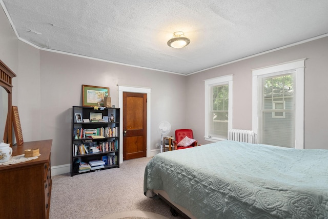 bedroom with a textured ceiling, radiator heating unit, crown molding, and carpet flooring