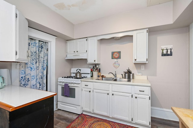 kitchen featuring light countertops, a sink, white cabinets, and white range with gas stovetop