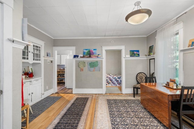 office with baseboards, crown molding, and wood finished floors