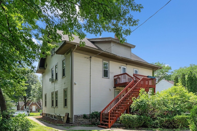 rear view of house with a shingled roof, stairs, and a wooden deck