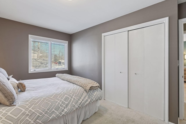 bedroom featuring light colored carpet and a closet