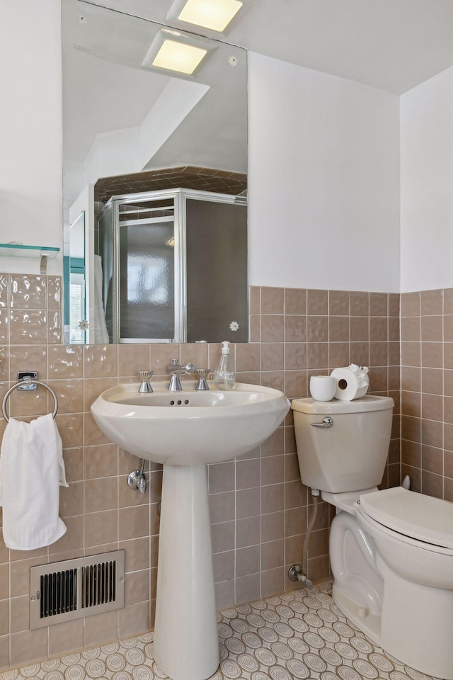 bathroom featuring tile walls, tile patterned flooring, and toilet