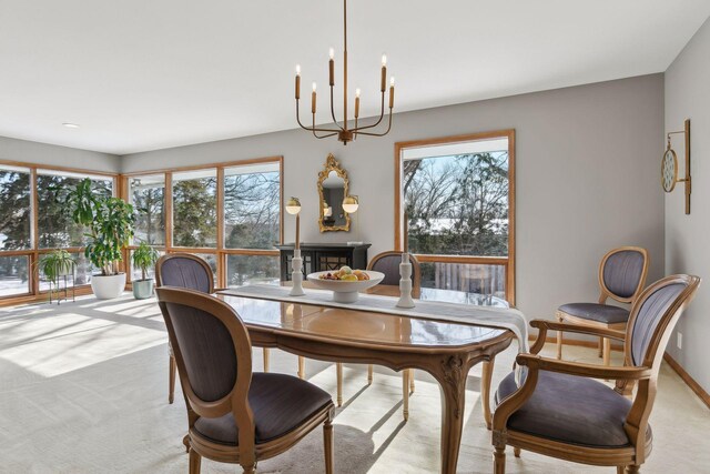 dining space featuring light colored carpet, a healthy amount of sunlight, and a notable chandelier