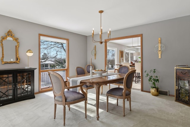 dining room featuring light colored carpet, plenty of natural light, and a notable chandelier