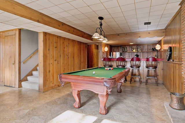 game room with pool table, wooden walls, and bar area