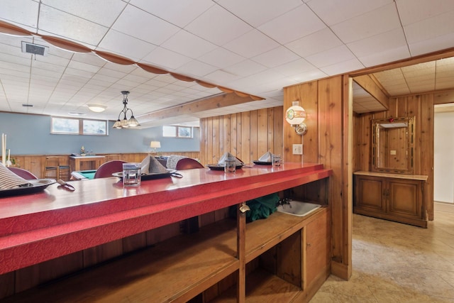 interior space featuring wood walls and decorative light fixtures