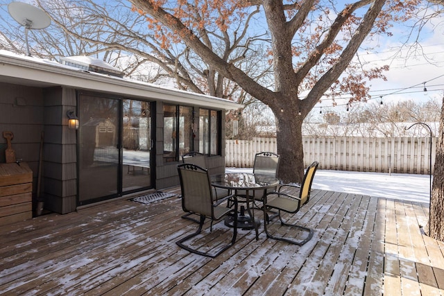 snow covered deck with a sunroom