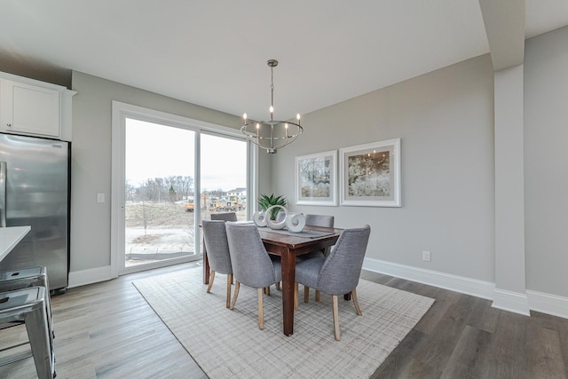 dining area with wood-type flooring and an inviting chandelier