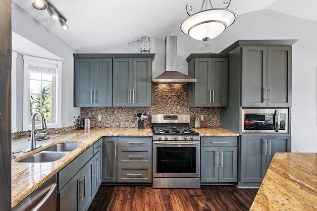 kitchen with a sink, lofted ceiling, wall chimney exhaust hood, and stainless steel appliances