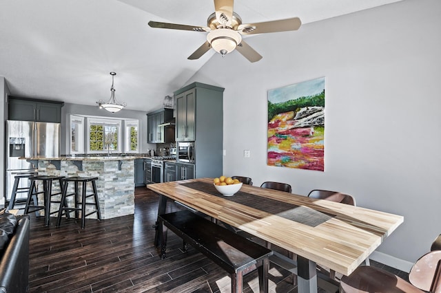 dining space featuring vaulted ceiling, ceiling fan, and dark wood-style flooring