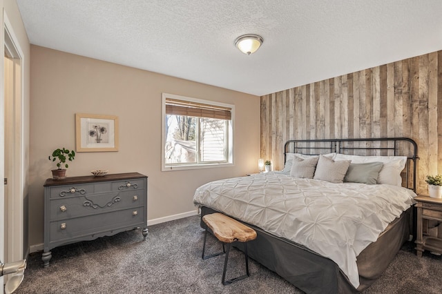 carpeted bedroom featuring baseboards, wood walls, and a textured ceiling