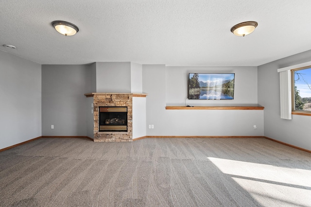 unfurnished living room featuring a fireplace, a textured ceiling, baseboards, and carpet floors