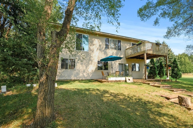 back of house featuring a lawn and a wooden deck