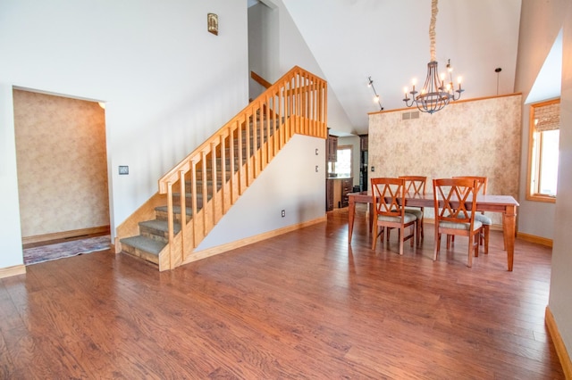 dining space featuring an inviting chandelier, hardwood / wood-style flooring, and high vaulted ceiling