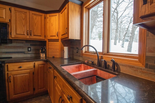 kitchen featuring sink, decorative backsplash, and stove