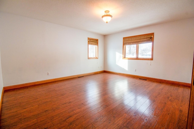 empty room featuring hardwood / wood-style flooring and a textured ceiling