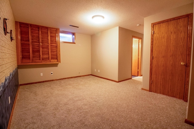 empty room featuring light colored carpet and a textured ceiling