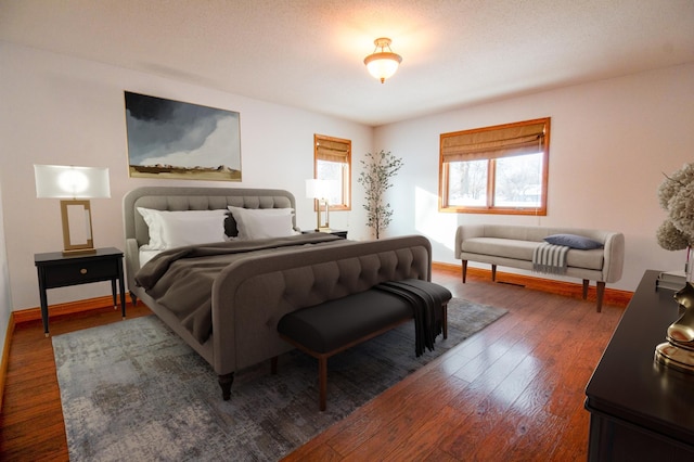 bedroom with a textured ceiling and dark hardwood / wood-style flooring